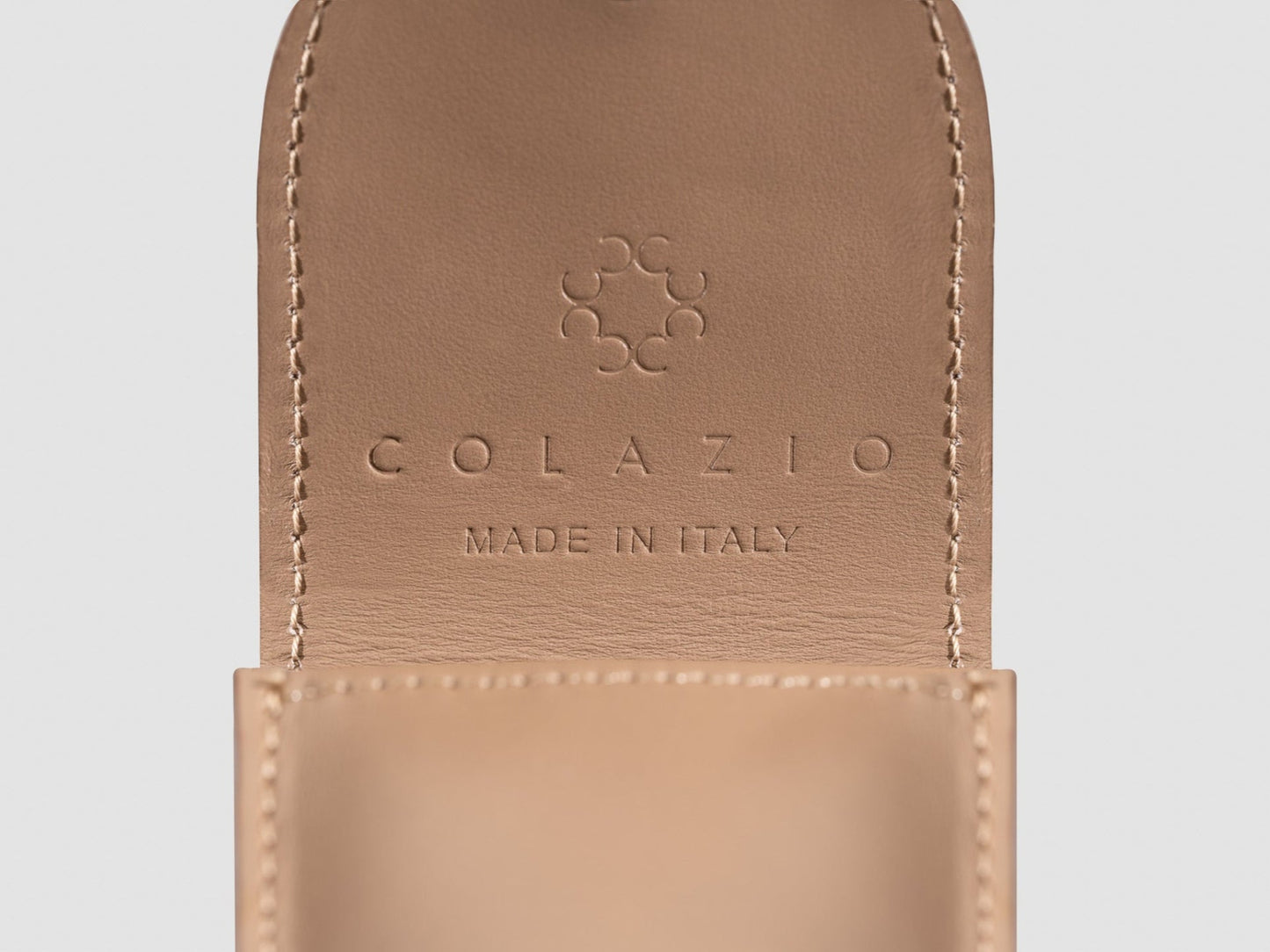 Close-up of a tan leather product with 'Colazio' branding and 'Made in Italy' text on a light gray background.